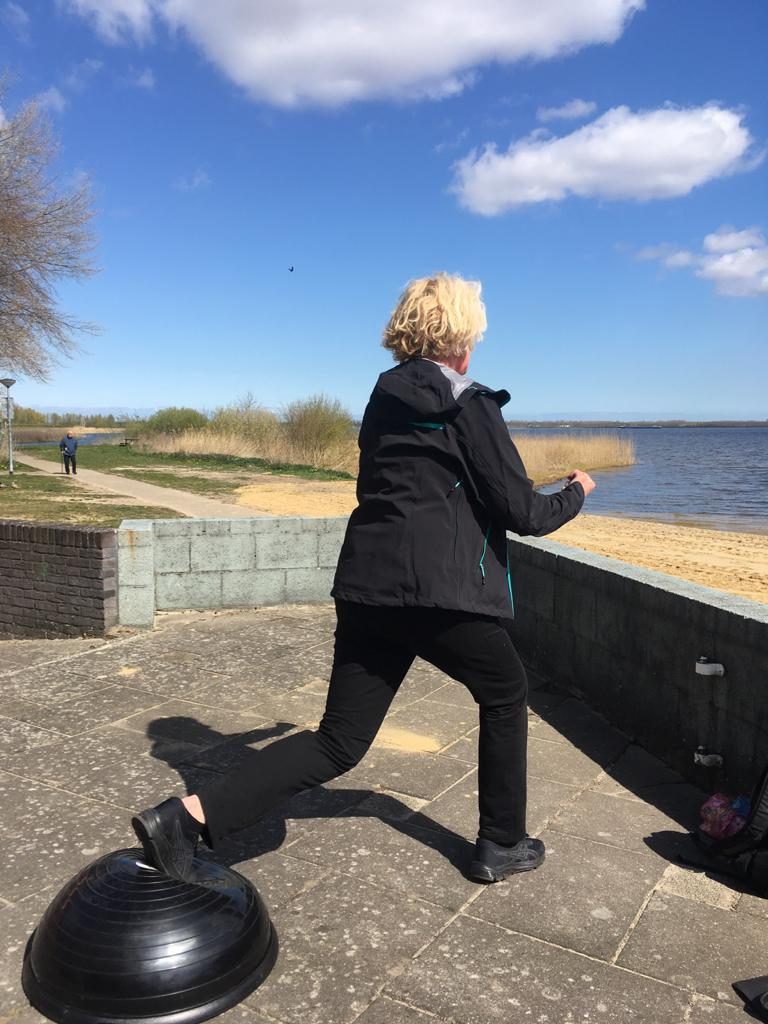 Vrouw traint op een balanstrainer bij het water