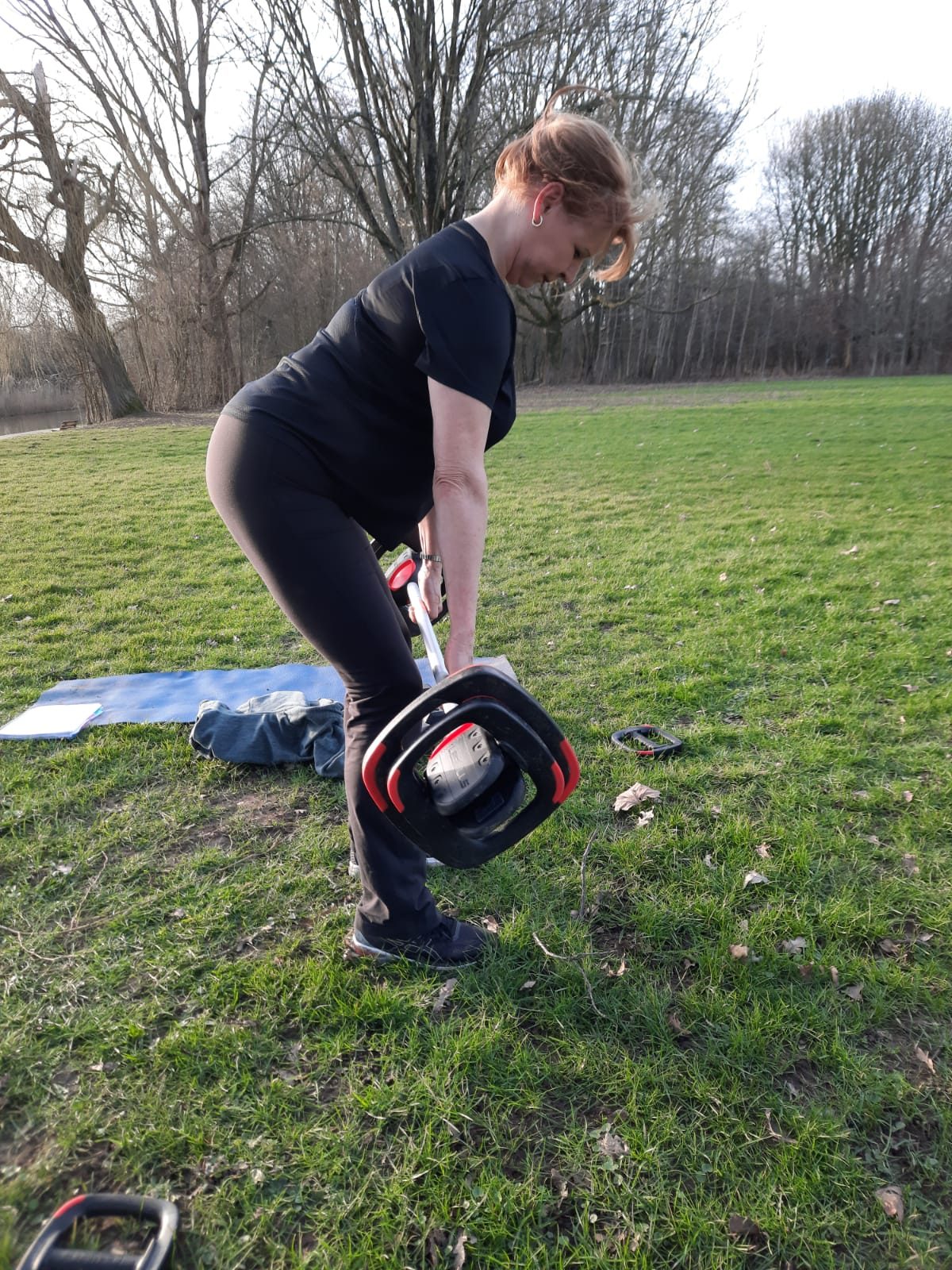 Vrouw tilt een gewicht op van het gras
